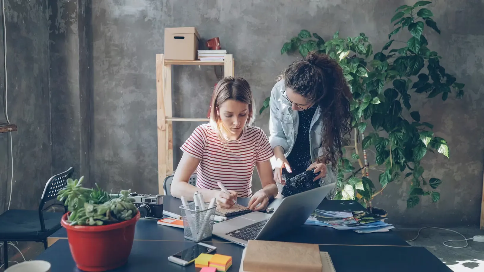 Zwei Frauen arbeiten gemeinsam vor einem Laptop